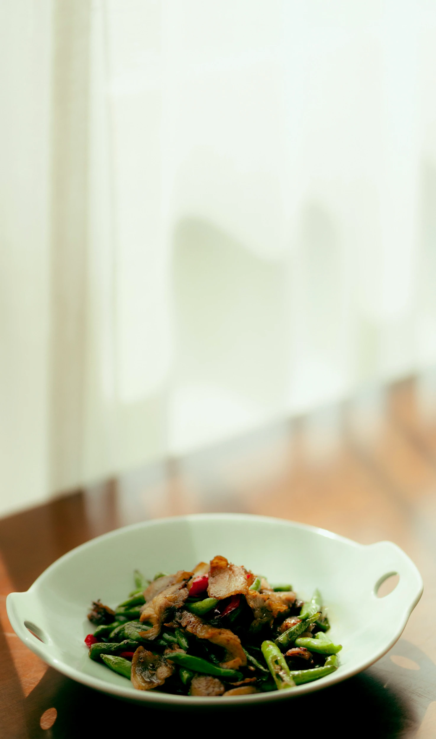 a bowl with food on a table in front of a window