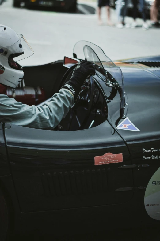 a man sitting in a car with a racing helmet on
