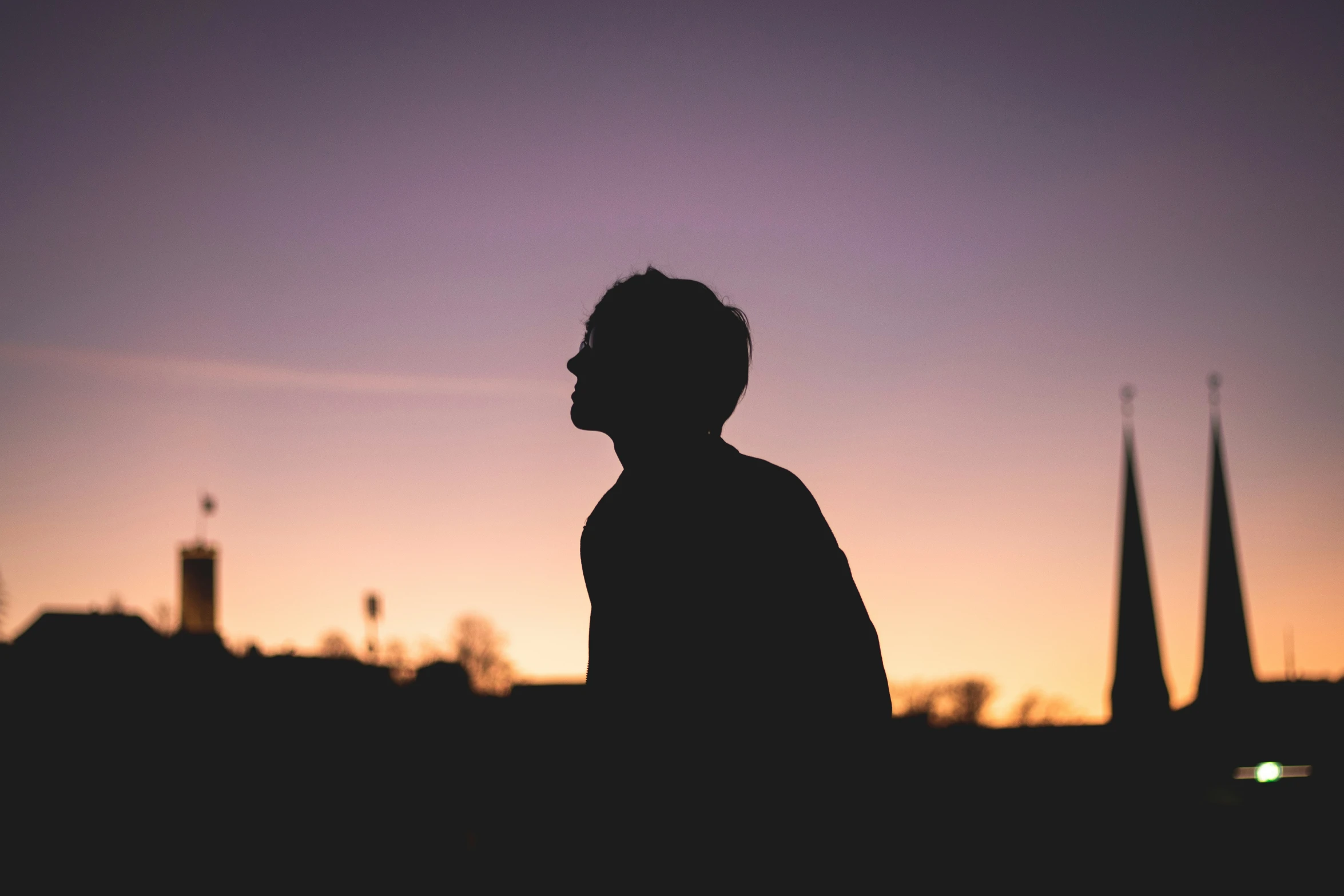 a man stands silhouetted against an overcast skyline