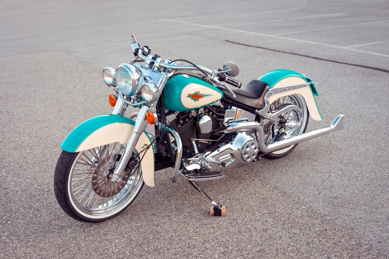 a turquoise and white motorcycle parked in a parking lot