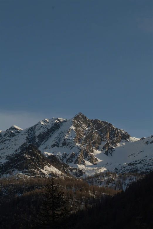 a mountain covered in lots of snow under a blue sky