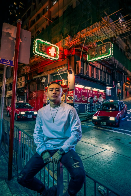 a man is posing on a railing in front of buildings