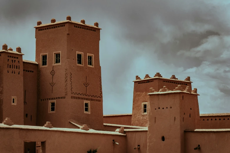 two tall buildings stand against a cloudy sky