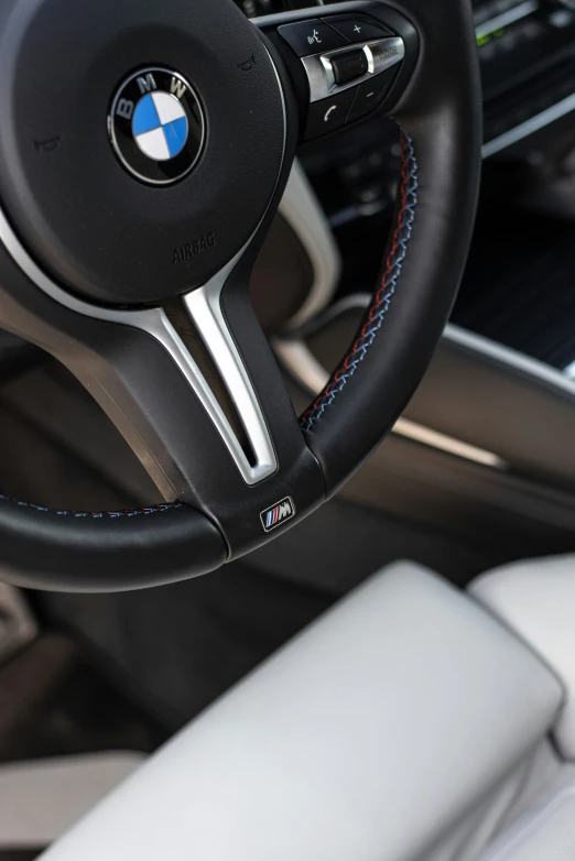 a steering wheel of a vehicle with a blue stitching