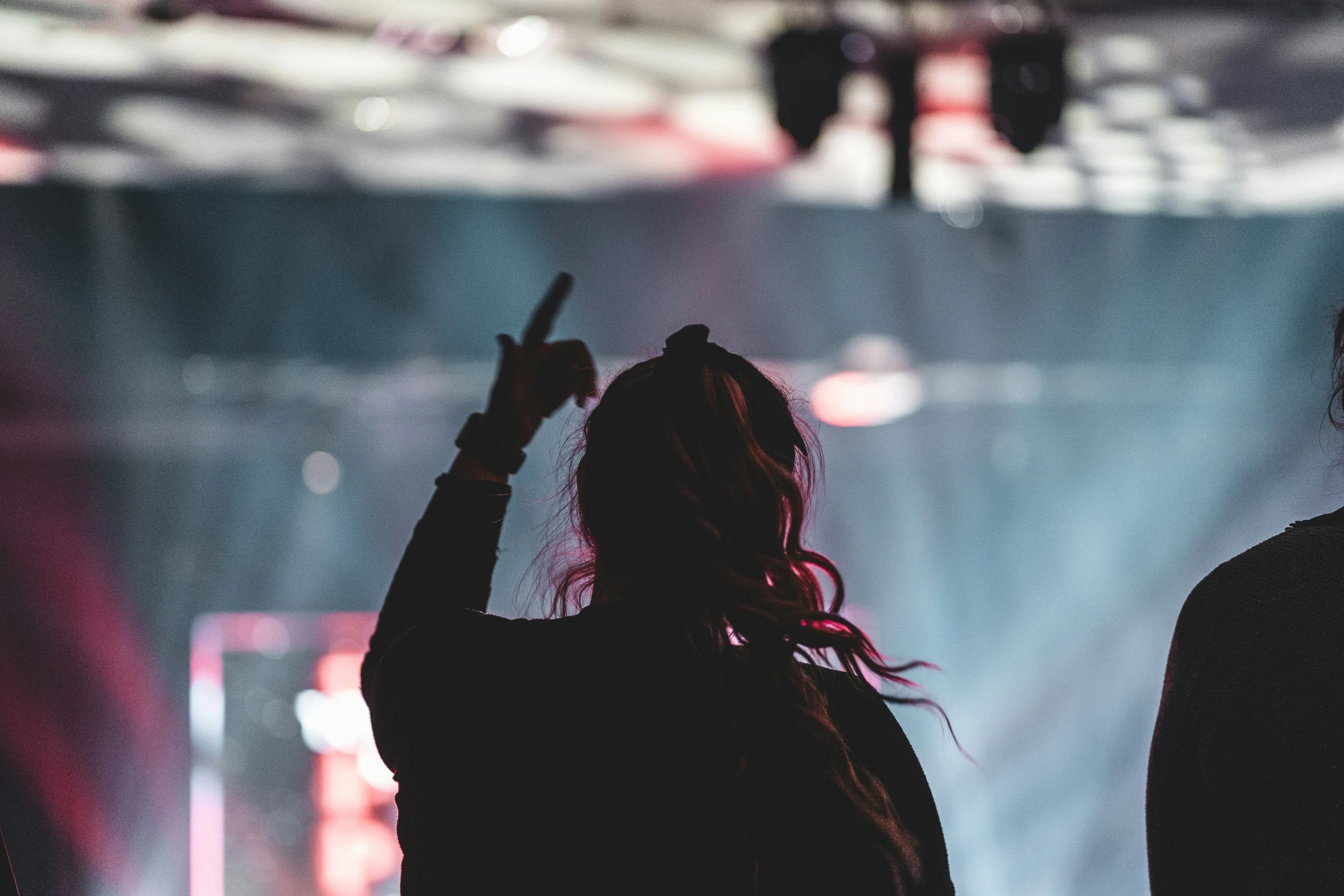 two people who are standing with their arms in the air