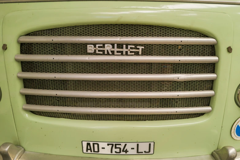 the front grille on a green truck with black lettering