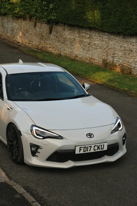 a white sports car is parked on the road