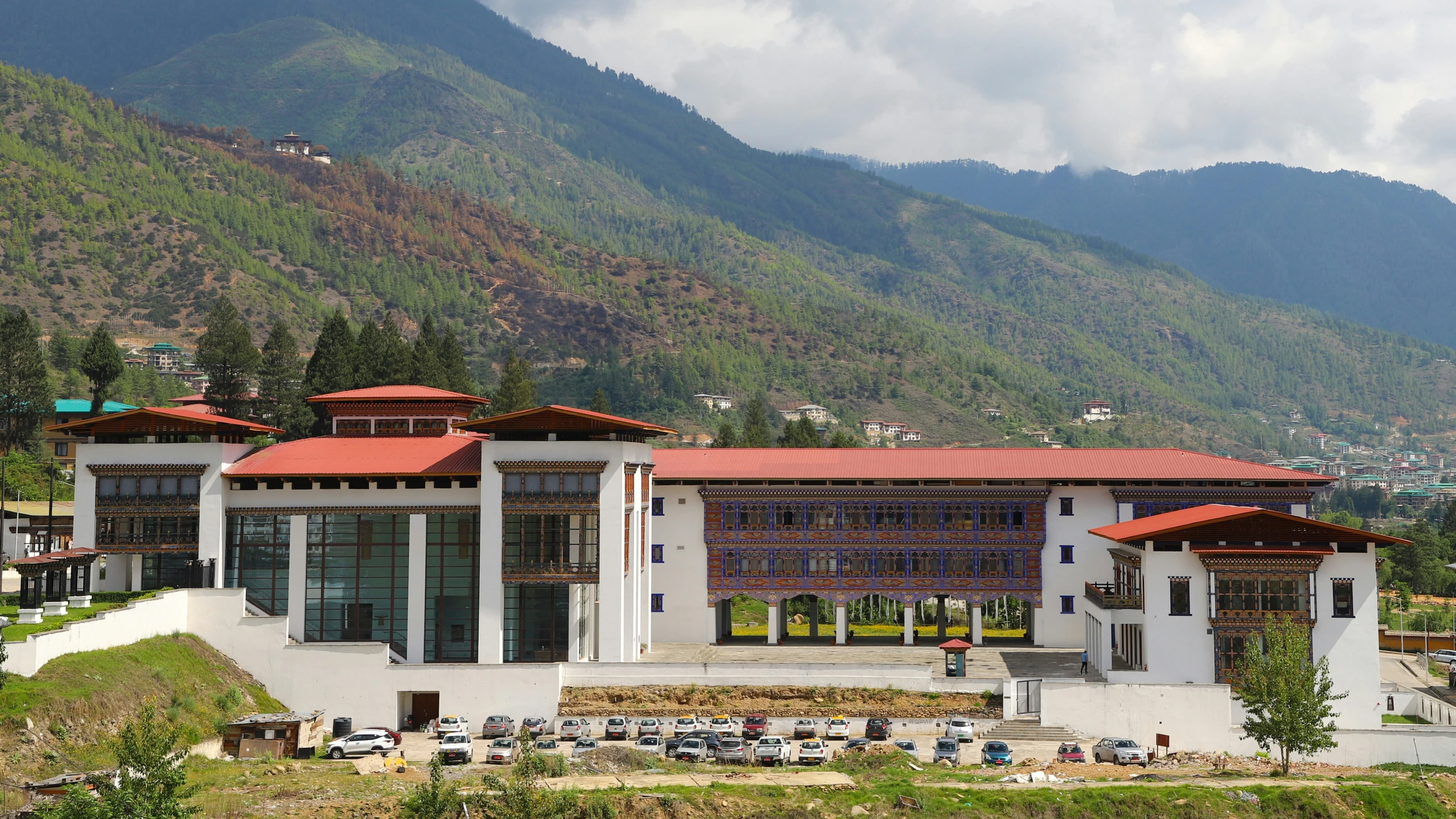 an elaborate building with lots of windows and mountains in the background