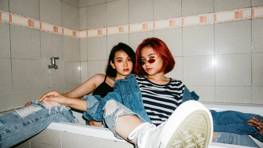 two people sitting in a bathtub in a bathroom