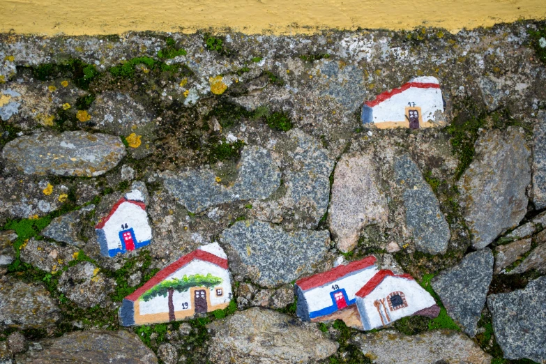 three tiny houses sitting on a rocky surface