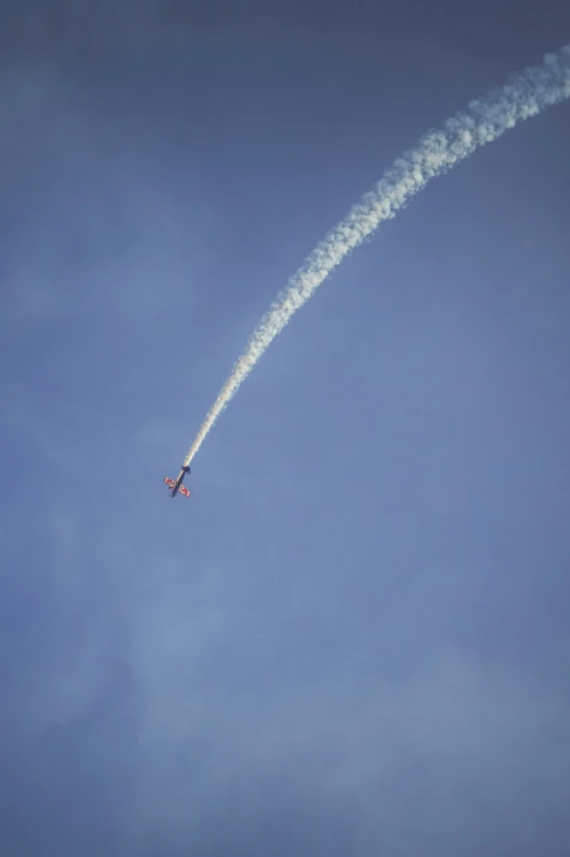 a smokestack is flying in the air, leaving a trail