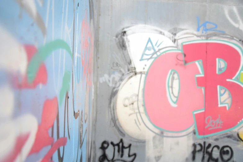 a graffiti filled wall is shown with letters and numbers