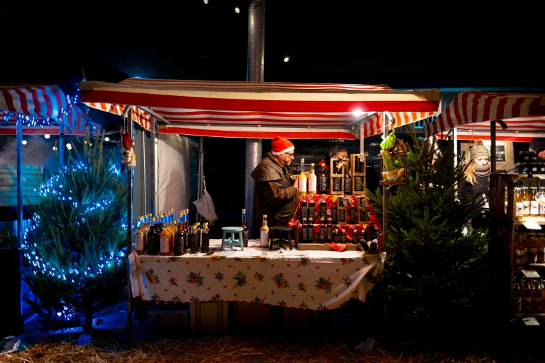 a woman standing at a table that has a christmas tree in the corner