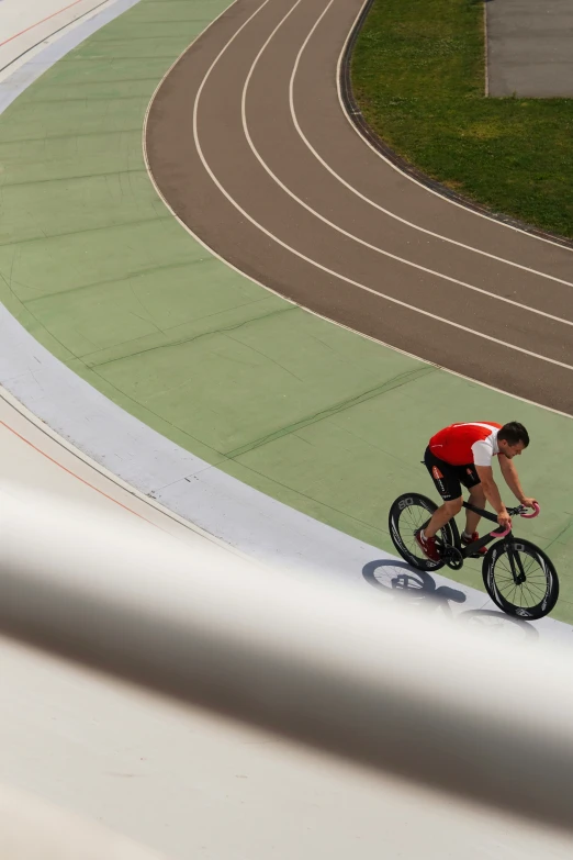 a man on a bike rides down a curve in a track