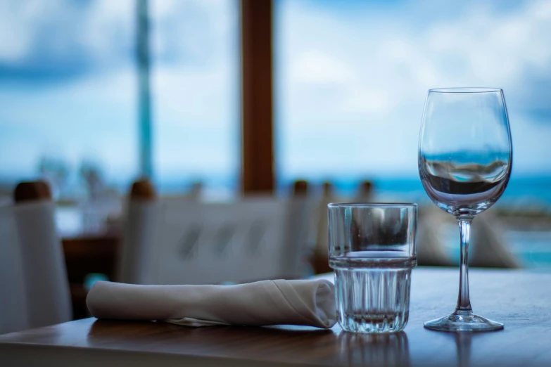 a glass of wine next to a napkin and glasses