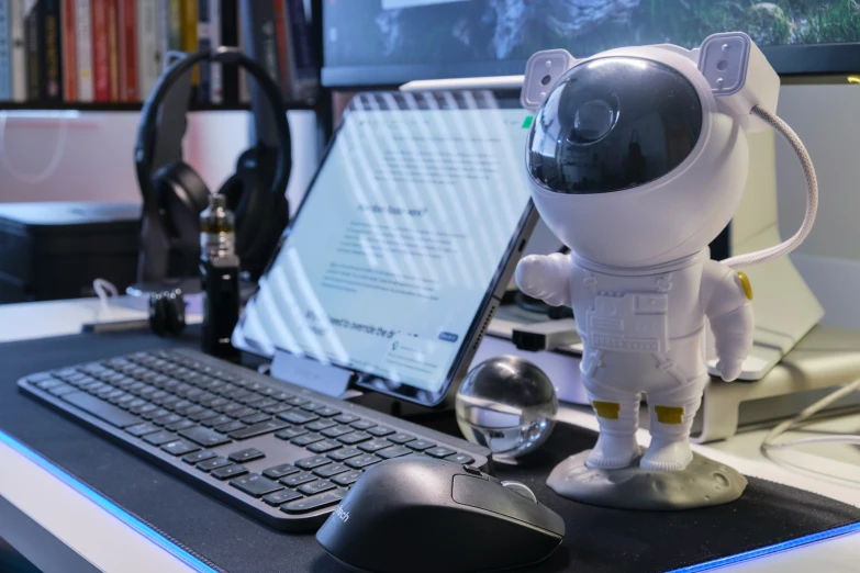 a usb mouse sitting next to an artificial toy, on a desk