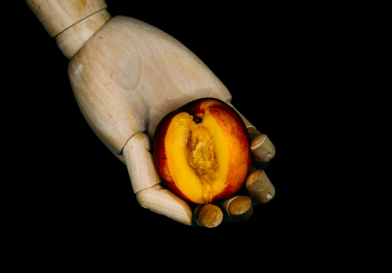 a hand holding an apple and nut shell