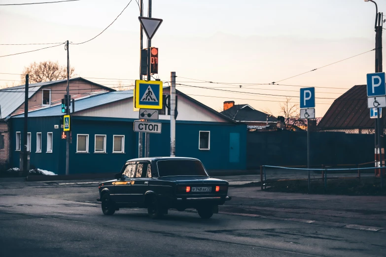 black car on the street with buildings in background