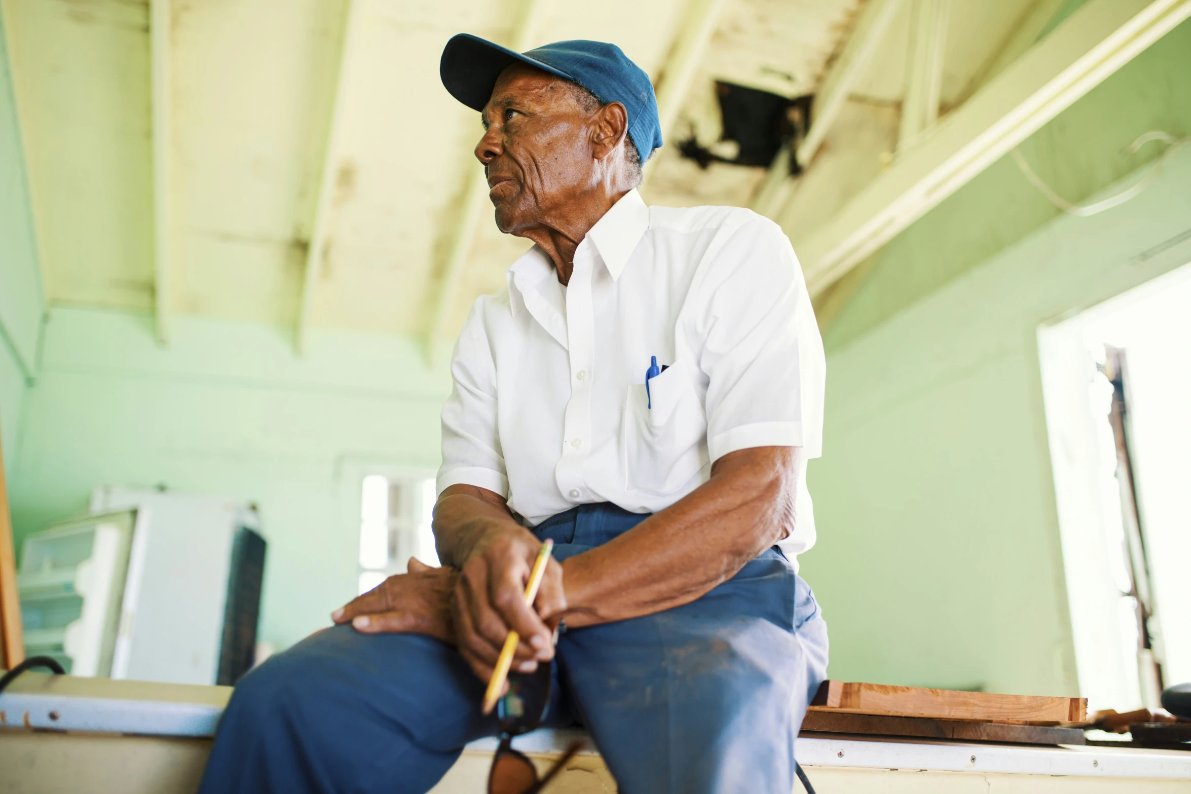 a man sitting on a stool and holding a cigarette