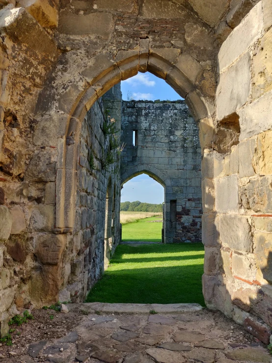 an archway is leading to a field outside