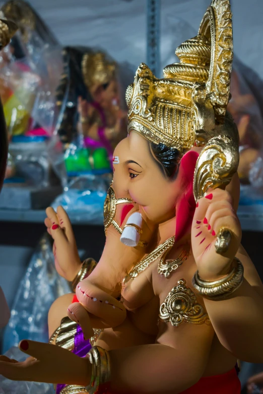 a girl sitting on the ground in a temple while holding onto her gold statue