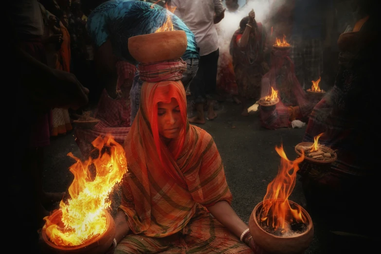 women sitting on the ground with fire in their hands