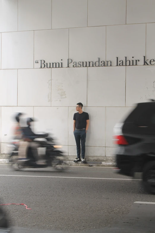 a man is standing on the sidewalk by a building