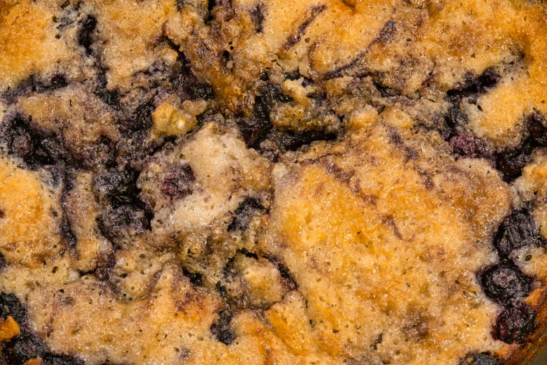 a closeup view of a blueberry cobble cake with crumbs on it