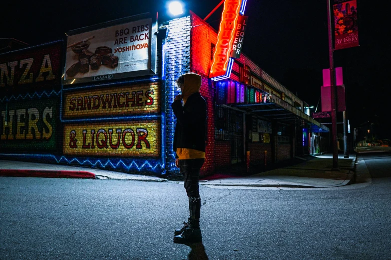 a man standing next to an outside restaurant at night