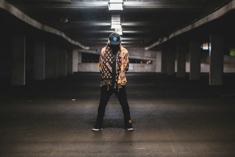 a young man is standing in the dark under a garage