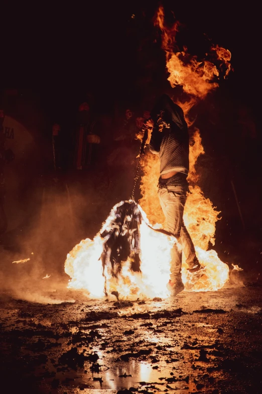 a person dancing with their fire stick on a night stage