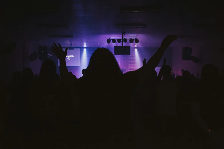 the audience in the dark waving their hands up