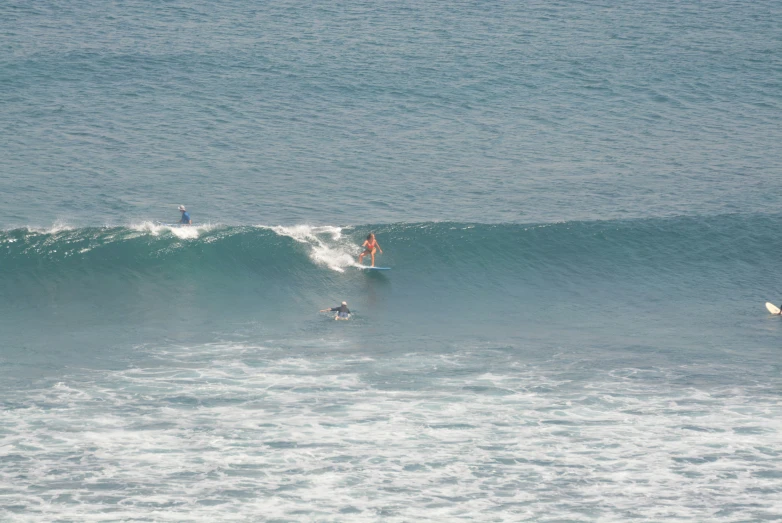 two people on surfboards riding the waves