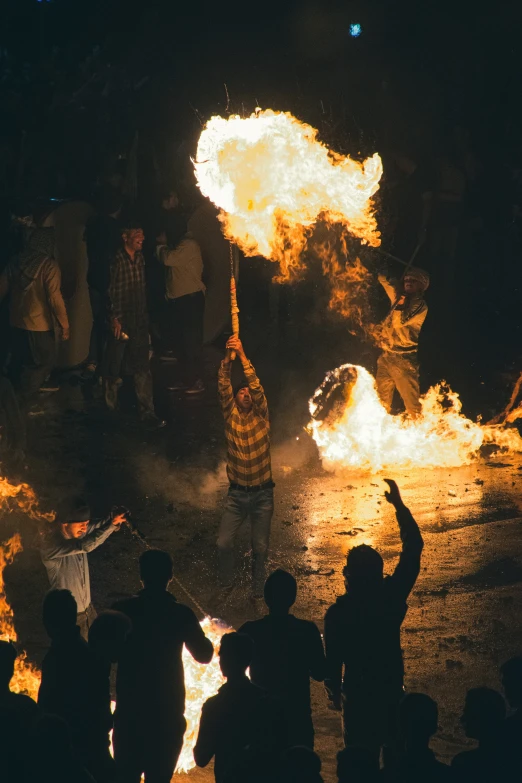 a crowd of people standing around a burning fire