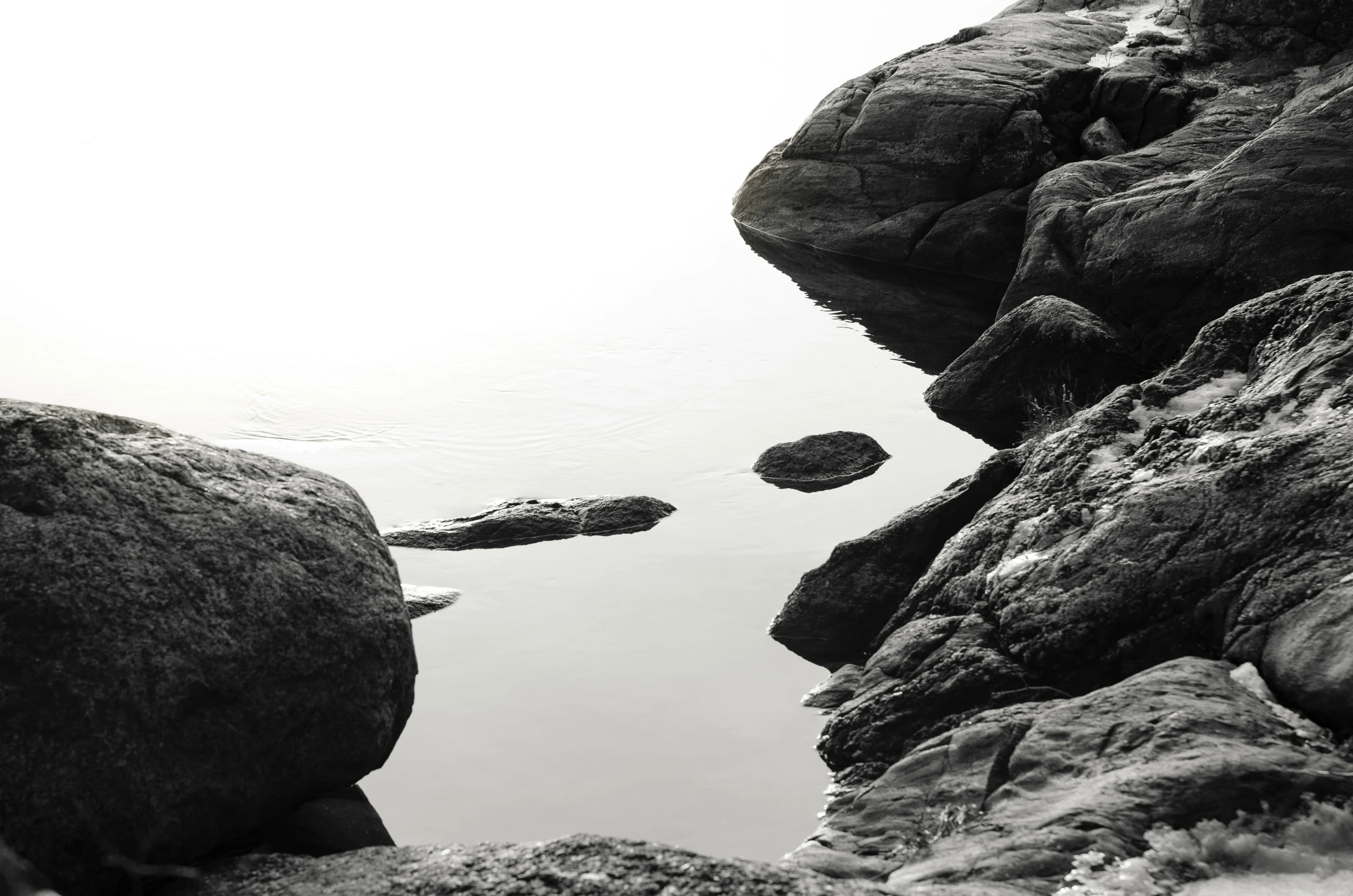 two rocks are next to a body of water