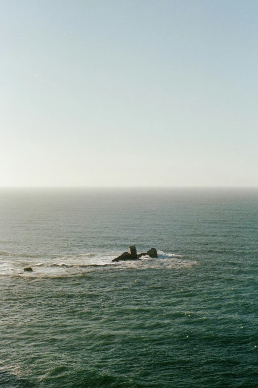 two people are riding a surfboard in the ocean