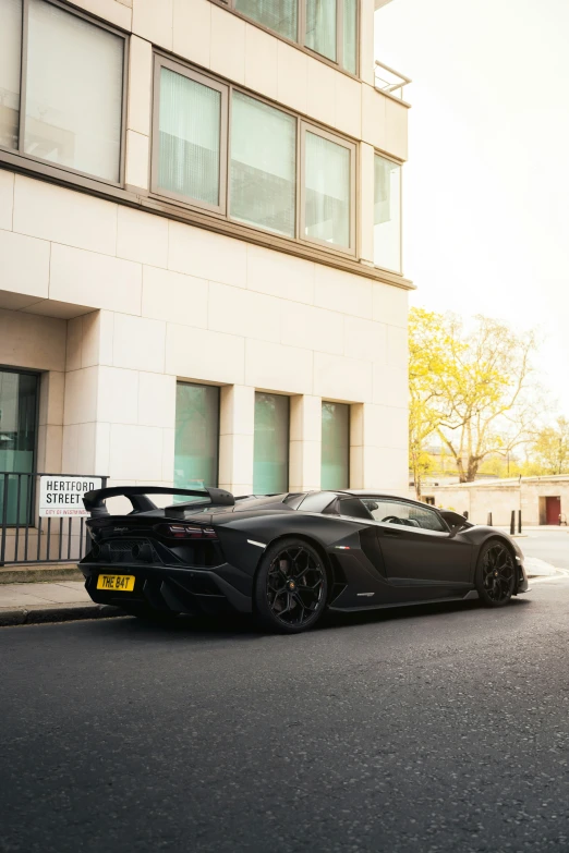 the black sports car is parked in front of the building