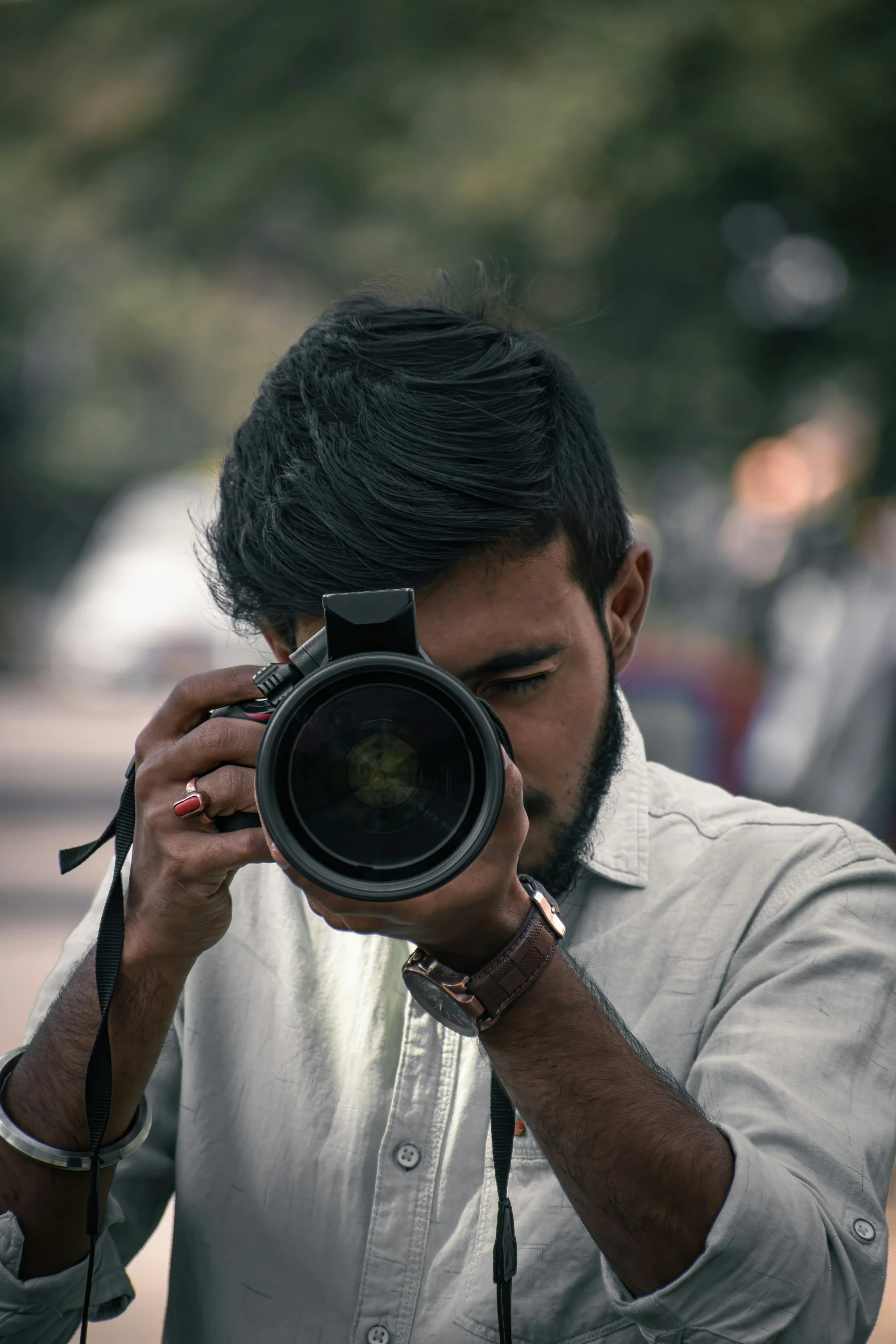 an indian man taking pos with his camera