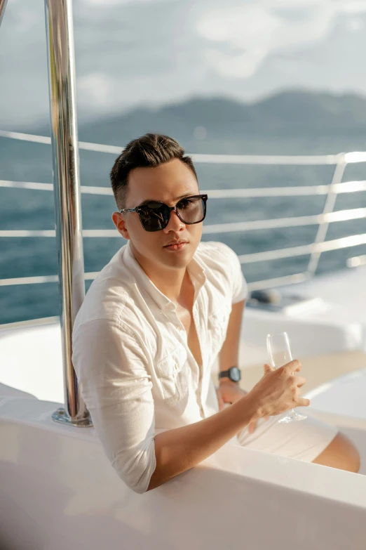 a man with sunglasses holding a glass of wine