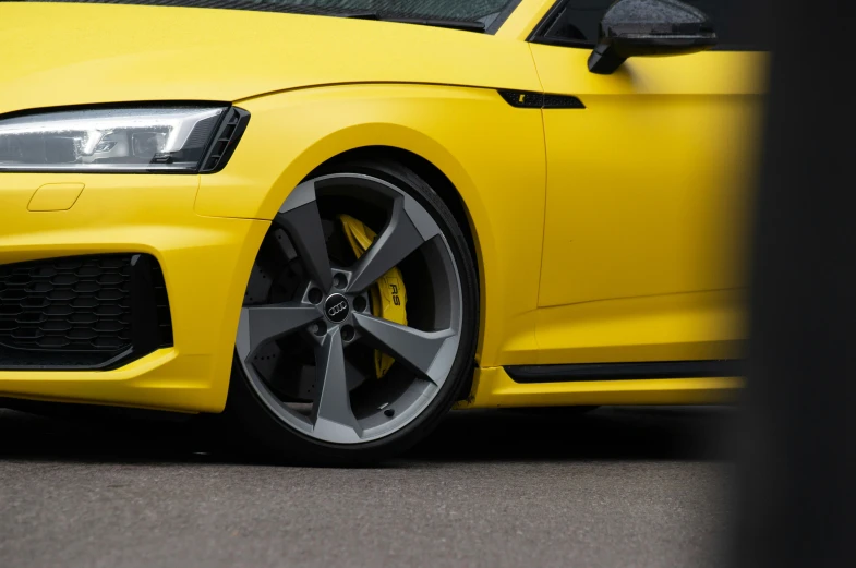 a car that is yellow with black spokes