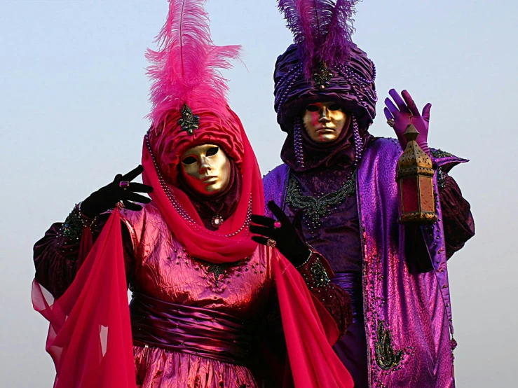 two men in costumes with an umbrella and a woman standing next to each other