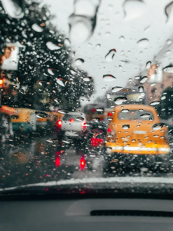 raindrops falling on a car windshield and looking out of a window