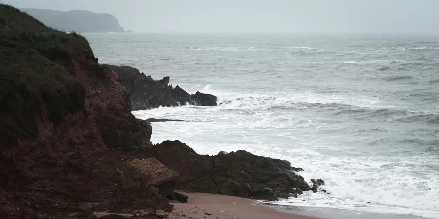 an ocean shore line with rocks on both sides