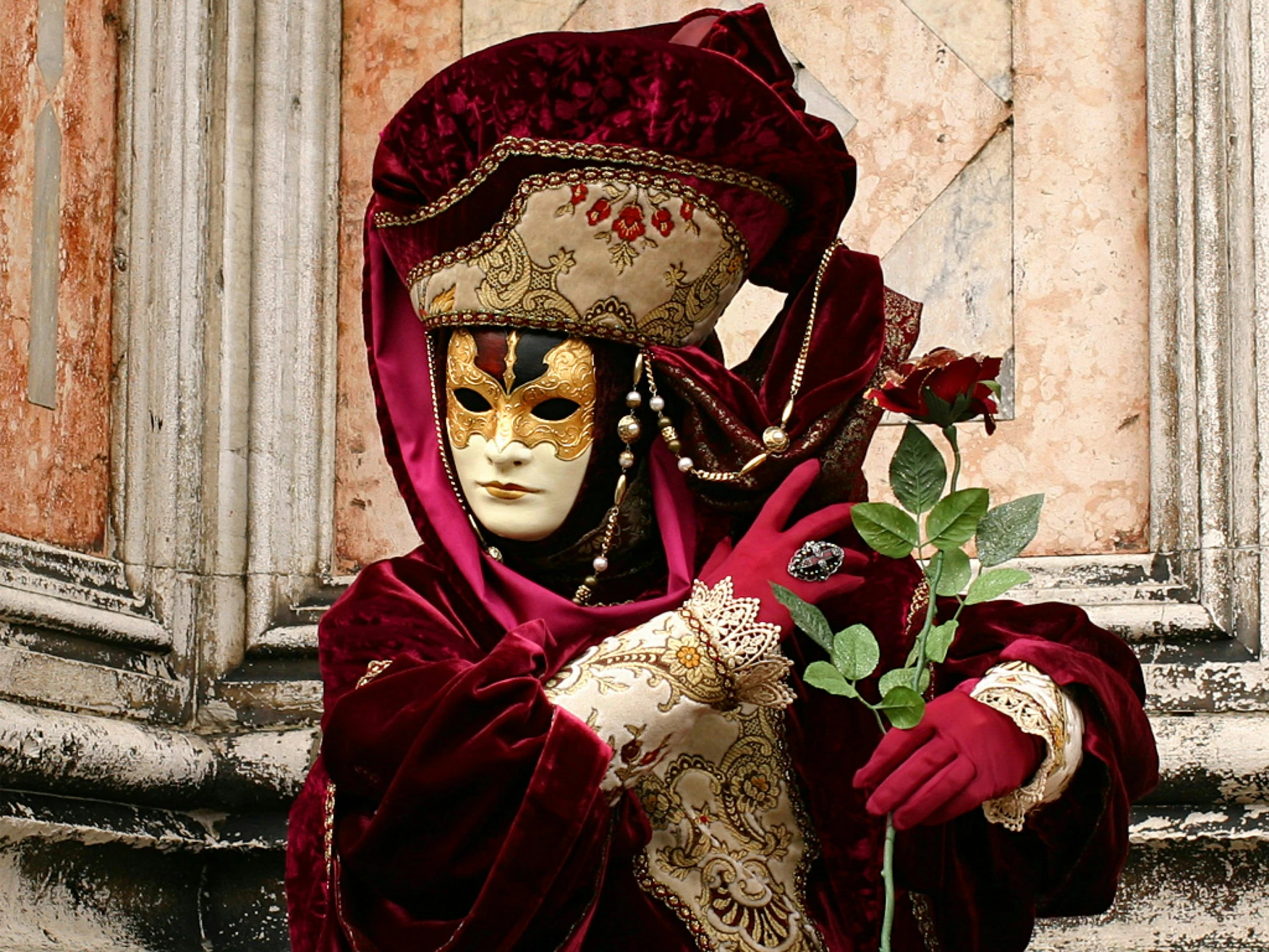 a woman wearing red is holding a flower