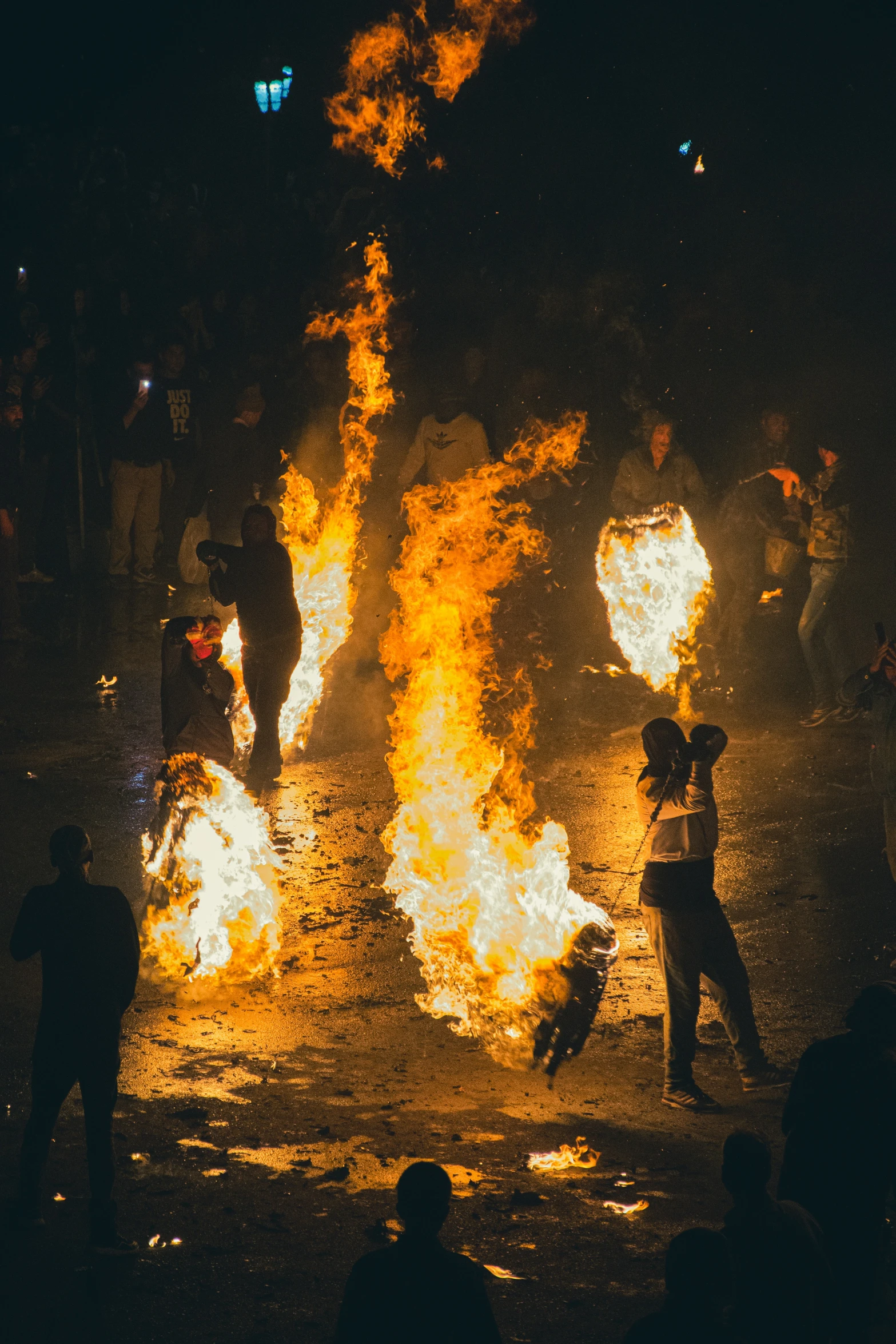 a group of people around a fire with flames burning