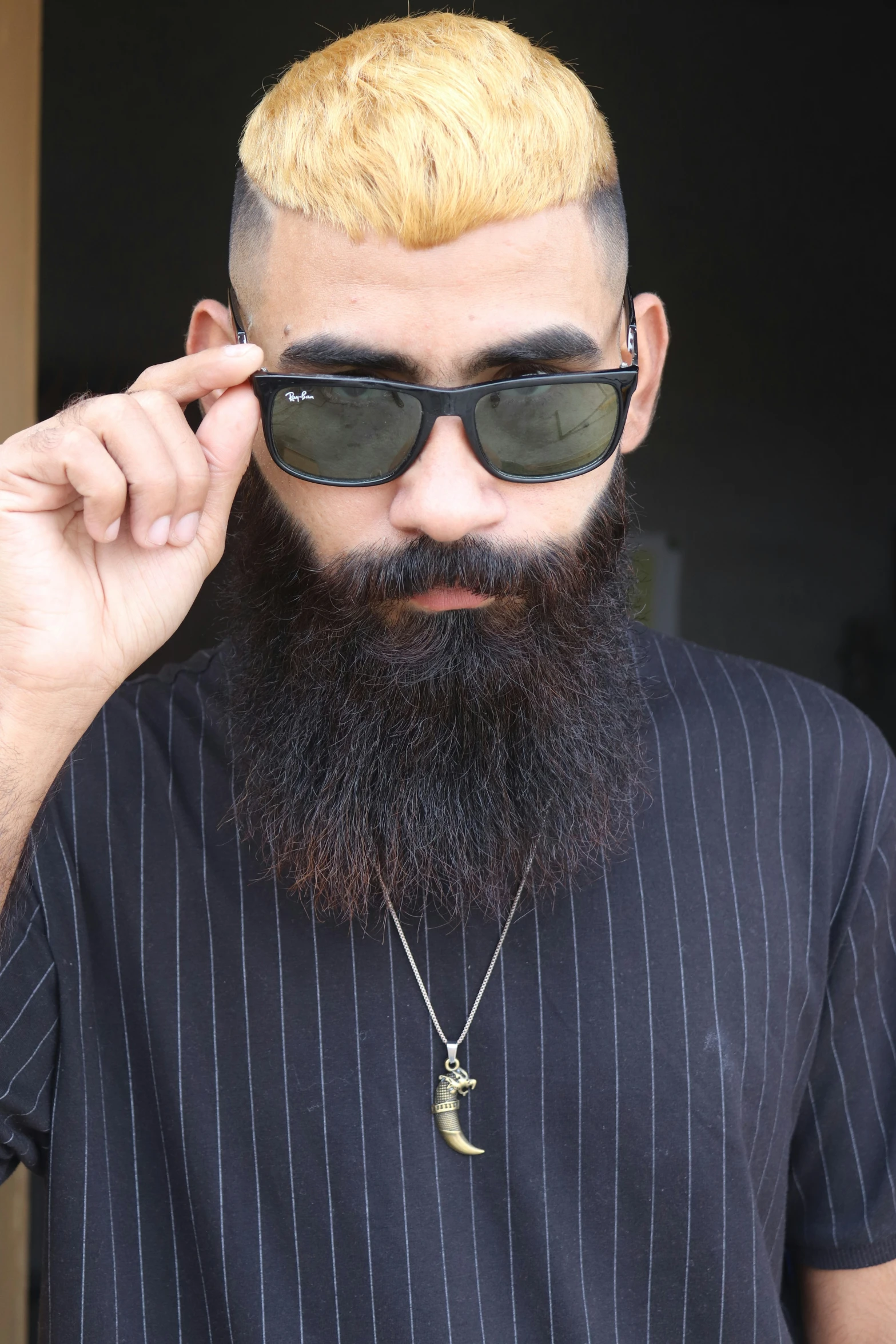 a man with a long beard and a beard piercing wearing sunglasses