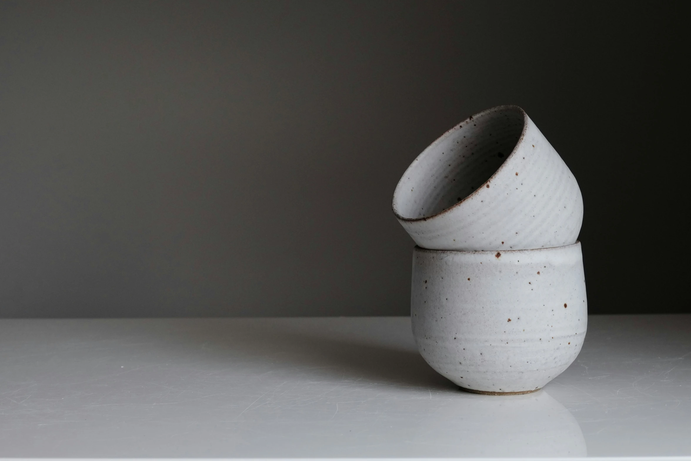 white ceramic vase placed on plain surface on gray background