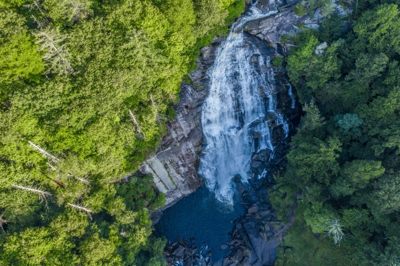 an aerial view of a waterfall in the forest