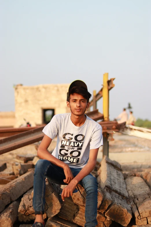 a young man sitting on a pile of rocks