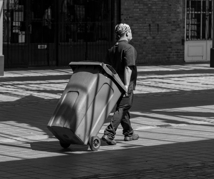 a man rolling a large suitcase on wheels